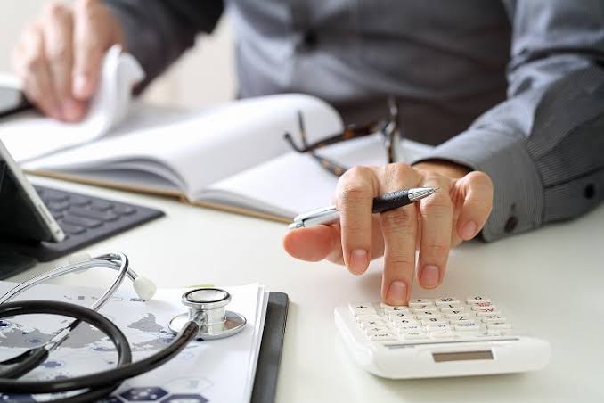 Doctor completing patient medical records and paperwork